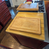 Eaglecreek Boards rectangular hardwood cutting board with juice groove resting on a kitchen island countertop