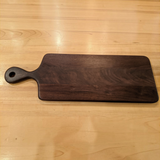 Eaglecreek Boards walnut wood paddle cutting board with a smooth dark finish and a convenient handle hole