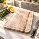 Eaglecreek Boards maple edge grain cutting board on a kitchen counter with a chef knife, rosemary, and lemon.